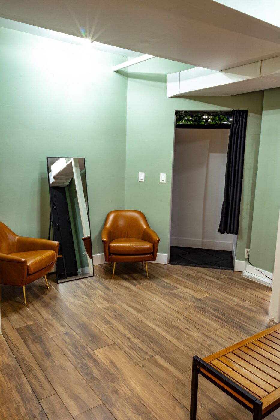 Ladies' lounge — leather chairs, mirror, and curtained changing area